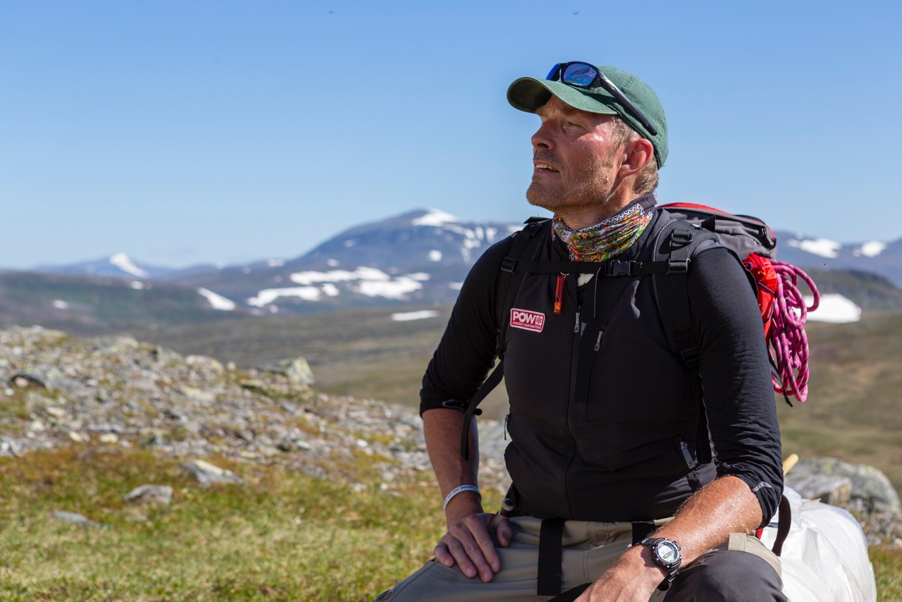 Portrait of Erik Huss with mountains in the background.