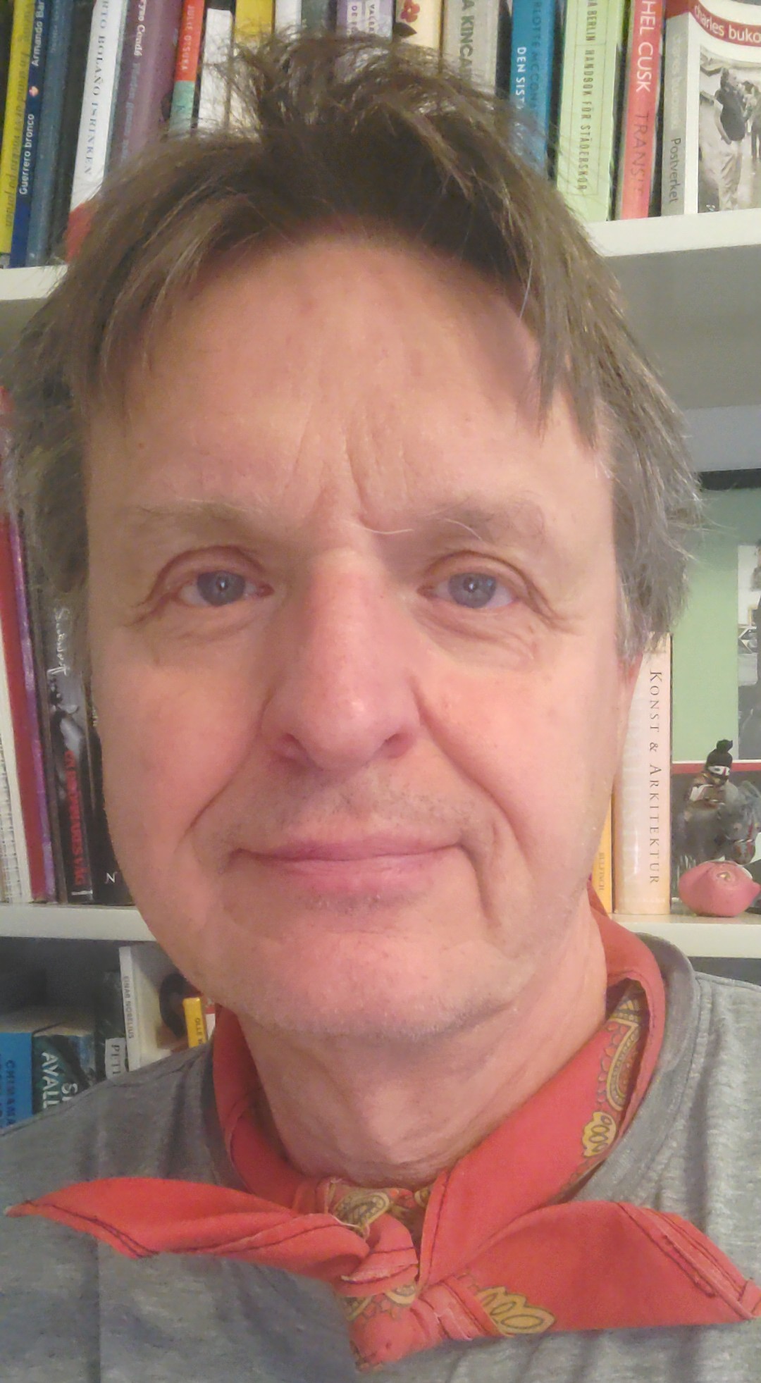 Portrait of Mikael Ros&eacute;n with a bookshelf in the background.